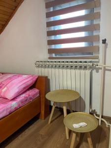 a bedroom with a bed and a table and a window at Guest House Husejn in Dubrave Gornje