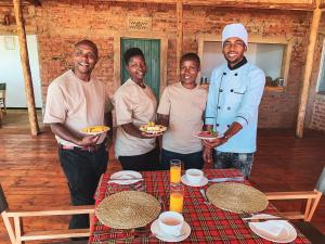 Un gruppo di uomini che si aggirano intorno a un tavolo con uno chef di Foresight Eco Lodge & Safari a Karatu