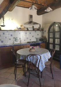y cocina con mesa, sillas, mesa y fogones. en antica dimora en Barbarano Romano