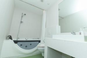 Baño blanco con aseo y lavamanos en Budapest Bed and Breakfast en Budapest