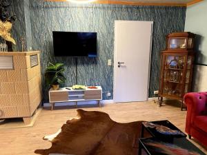 a living room with a flat screen tv on a wall at im Haus zur Auszeit willkommen in Ruhla