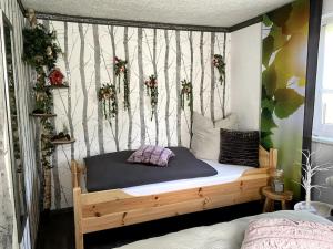 sypialnia z drewnianym łóżkiem i ścianą drzewną w obiekcie im Haus zur Auszeit willkommen w mieście Ruhla