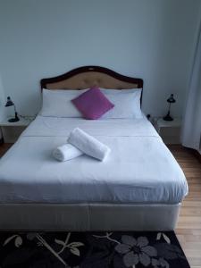 a bed with two towels sitting on top of it at Shaftsbury residence cyberjaya with a pool & Free Parking in Cyberjaya