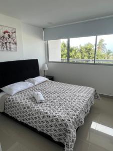 um quarto com uma cama com um edredão preto e branco em Sunny House em Cartagena das Índias