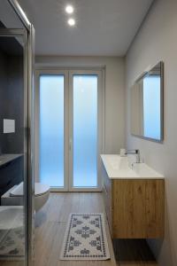 a bathroom with a sink and a toilet and a mirror at HABITAT- Apartments&Rooms in Cerignola