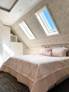 a bedroom with a large bed with two skylights at Hotel DARDANIA in Kukës