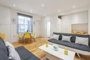 a living room with a couch and a table at Deluxe Flat A in Kensington Olympia in London