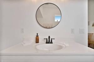 Baño blanco con lavabo y espejo en Beautiful newly remodeled home, near JT Park, en Joshua Tree