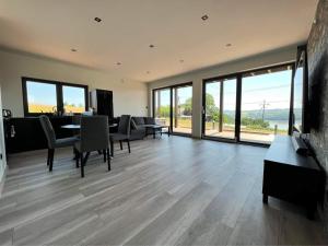 a living room with a table and chairs and windows at Wichrowe Wzgórze z jacuzzi in Znamirowice