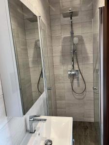 W łazience znajduje się prysznic i biała umywalka. w obiekcie Wichrowe Wzgórze z jacuzzi w mieście Znamirowice