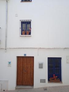 een wit gebouw met twee deuren en een raam bij Lake room Iznajar in Iznájar