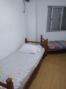 a bedroom with a bed and a window with a window at Apê Temporada Vila Guilhermina in Praia Grande +7 photos