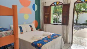 Schlafzimmer mit einem Bett und einem Fenster in der Unterkunft Pousada Sonho Meu in Porto Seguro