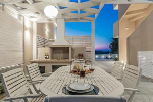 a dining table and chairs on a patio with a fireplace at Spartakos Luxury Villa 3 in Plános