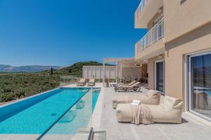 a villa with a swimming pool and a house at Spartakos Luxury Villa 3 in Planos