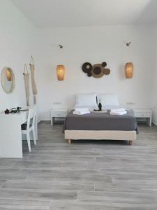 a white bedroom with a bed and a desk at Galazio Rooms & Suites in Batsi