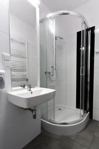 a white bathroom with a sink and a shower at Pawilon Sportowo Turystyczny Kalwarianka in Kalwaria Zebrzydowska