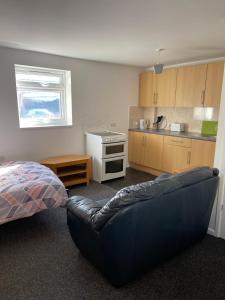 Spacious 9 bed house in Mansfield Nottinghamshire في مانسفيلد: غرفة معيشة مع أريكة ومطبخ