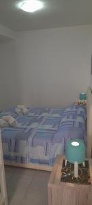 un letto con piumone blu e un tavolo in legno di Casa vacanza Gabry a Noto Marina