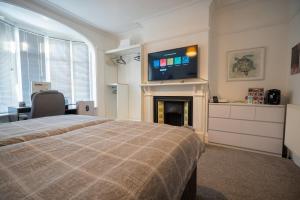 1 dormitorio con 1 cama y chimenea con TV en Cavendish Cat and Gaming House, en Blackpool