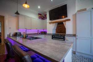 uma cozinha com um grande balcão com iluminação roxa em Cavendish Cat and Gaming House em Blackpool