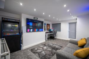 a living room with a couch and a large screen tv at Cavendish Cat and Gaming House in Blackpool