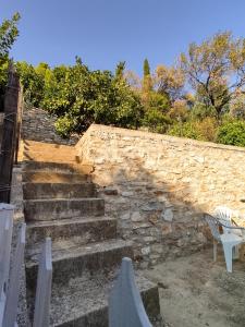 a stone wall with stairs and a white chair at Travelers Stasis Nafpaktos in Nafpaktos