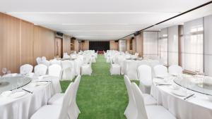 長沙市にあるHoliday Inn Changsha Malanshan, an IHG Hotelの白いテーブルと椅子が備わる会議室