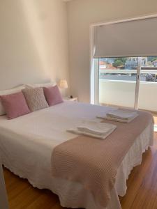1 dormitorio con 1 cama grande y 2 toallas. en Sunset Guest House, en Matosinhos