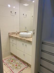 a bathroom with a sink and a mirror at Apartamento Novissimo Aquarius II in Poços de Caldas