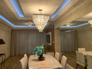 a dining room with a table and a chandelier at Apartamento Novissimo Aquarius II in Poços de Caldas