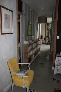 salon z żółtym krzesłem i półką na książki w obiekcie La Tropicale-Maison au calme avec 1 chambre w mieście Nantes