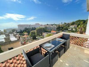 a balcony with a table and a view of the city at Nice Renting - CAMBRAI - Luxurious Sea View Terrasse - King Bed - Parking - AC - fully equipped in Nice