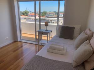 a white bed in a room with a large window at Sunset Guest House in Matosinhos