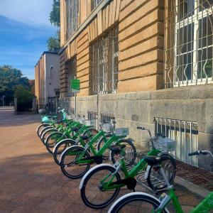 une rangée de vélos verts garés à côté d'un bâtiment dans l'établissement Apartament w kamienicy w sercu miasta Szczecin Wały Chrobrego, à Szczecin