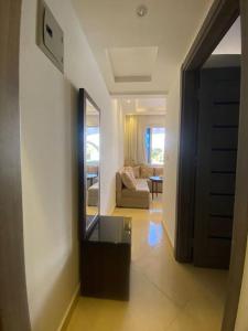 een woonkamer met een spiegel en een bank bij Studio on the ground floor in Sharm Hills Resort with private garden and pool view in Sharm El Sheikh