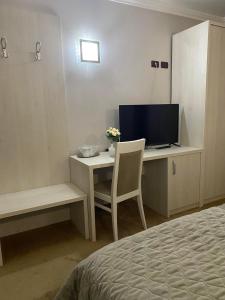 1 dormitorio con escritorio, TV y cama en Grand Master Hotel en Dej