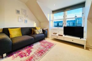 a living room with a couch and a flat screen tv at Stoney Hideaway in Stonehaven