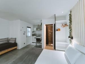 a white bedroom with a bed and a kitchen at -SKY- Appartement meublé cosy & confort-Parking privé & jardin in Laveyron