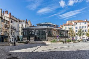 a building in the middle of a street with buildings at Gîte du rempart avec Balnéo, Garage, 2 SDB 2WC vue sur les monuments in Le Puy-en-Velay