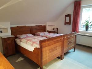 a bedroom with a wooden bed and a window at Große Ferienwohnung, auf Bauernhof mit Ponys und Pferden, ländlich und ruhig, Nähe Dümmer See in Holdorf