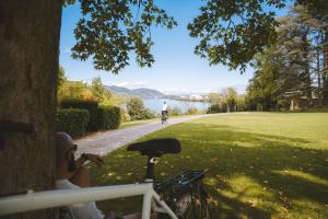 una persona montando una bicicleta en un camino junto a un lago en -SKY- Appartement meublé cosy & confort-Parking privé & jardin, en Laveyron