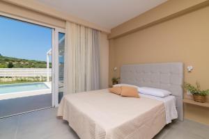 a bedroom with a bed and a large window at Spartakos Luxury Villa 4 in Plános