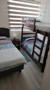 - une chambre avec 2 lits superposés et une fenêtre dans l'établissement Departamento encantador, à La Serena