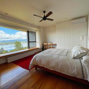 a bedroom with a bed and a large window at Hotel Casa Panguipulli in Panguipulli
