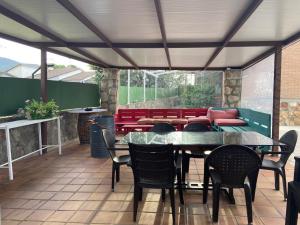 un patio con mesa, sillas y sofá en Casa de campo en pelayos, en Pelayos de la Presa