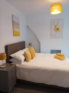 a bedroom with a large bed with yellow pillows at Victorian Renovation Room 8 in Liverpool