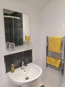 a bathroom with a sink and a mirror and towels at Victorian Renovation Room 8 in Liverpool