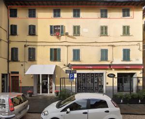 un coche blanco estacionado frente a un edificio en Mansarda Pescia, en Pescia