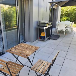 a patio with two benches and a grill and a table at Jolie suite parentale avec son coin de verdure à 5 minutes à pied du centre ville in Bordeaux